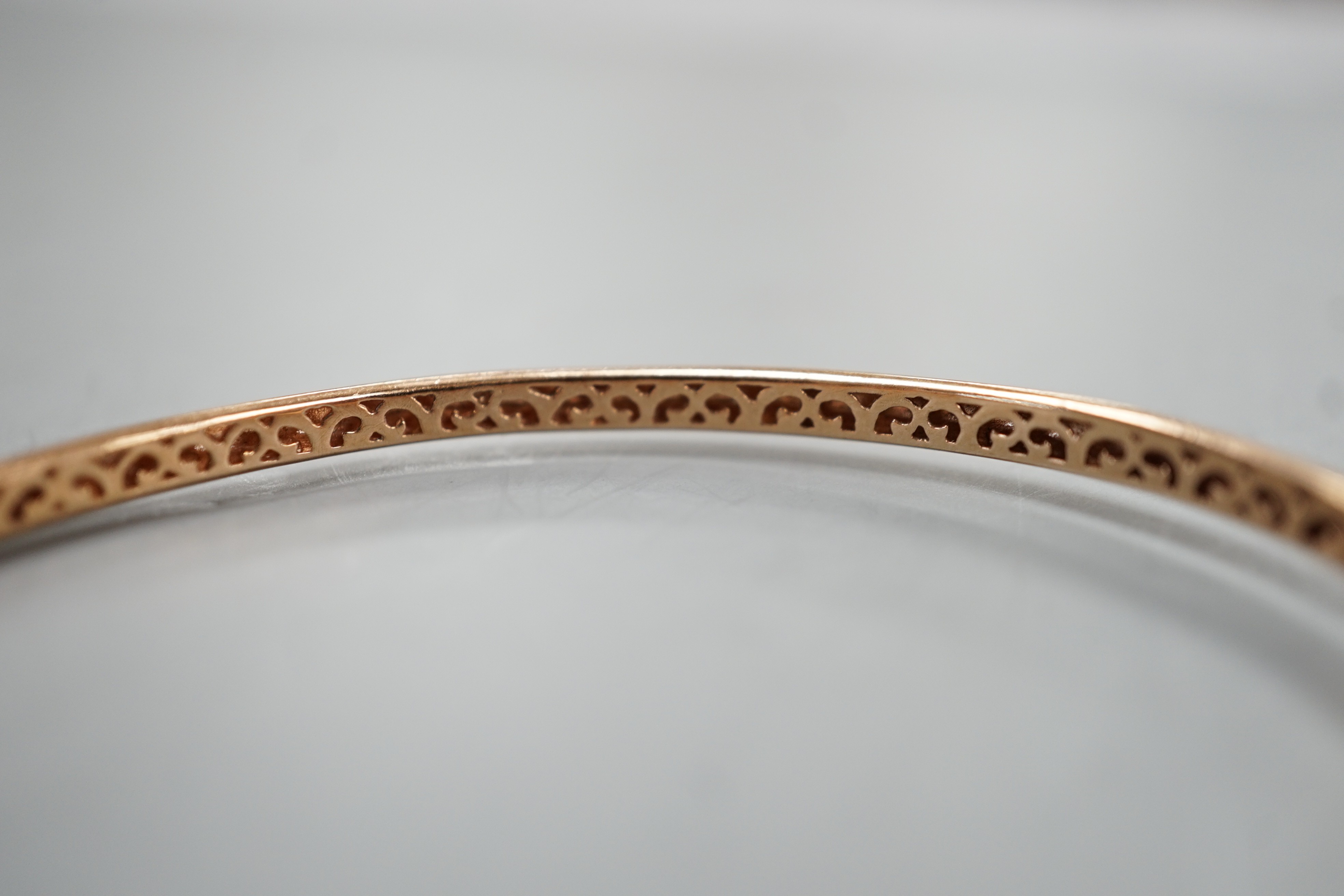 A modern 9k and nine stone gypsy set diamond hinged bangle, interior diameter 60mm, gross weight 9.3 grams.